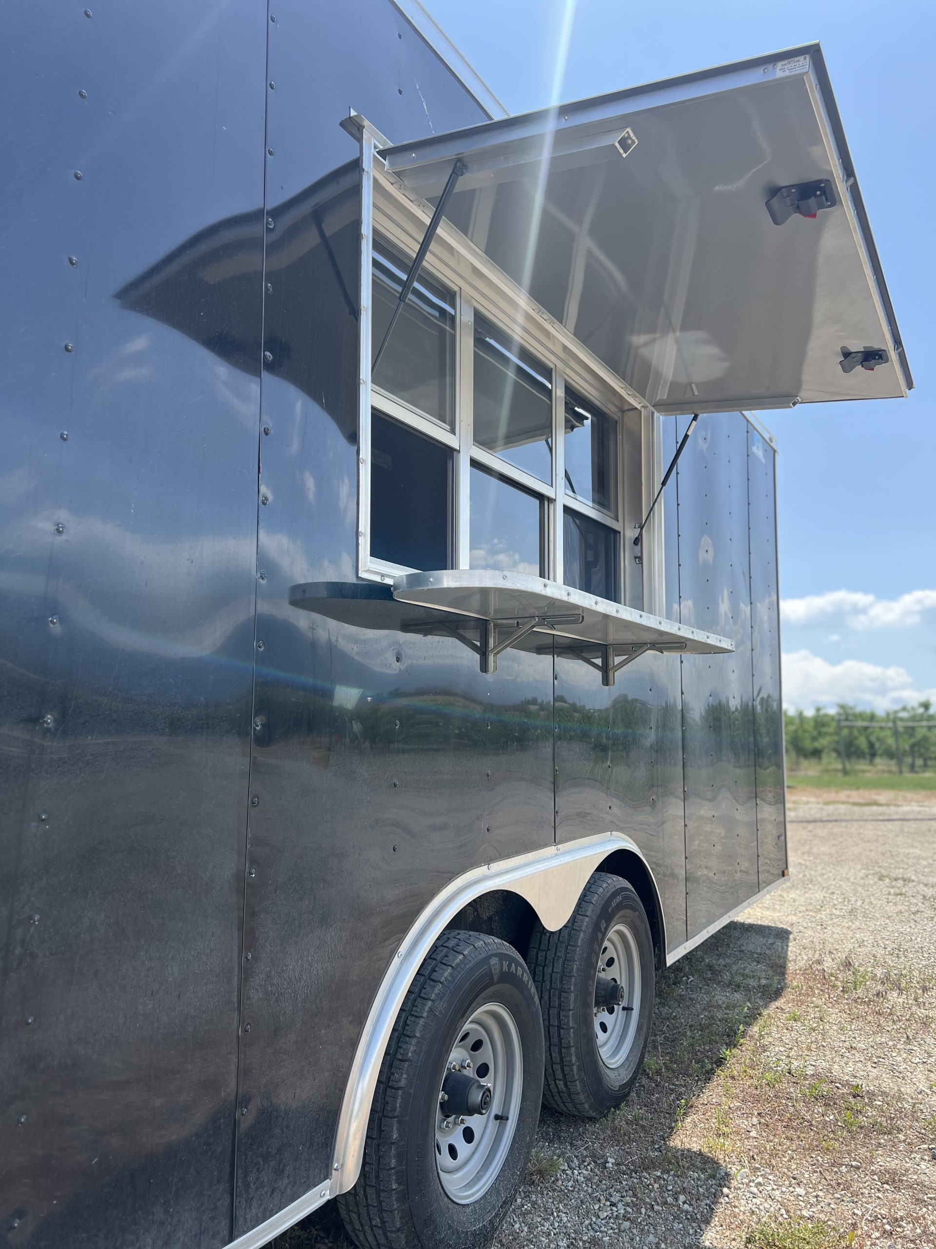 The Swanson's apple cider donut trailer from the exterior, with the serving window open.